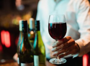 bartender-holding-glass-red-wine-1